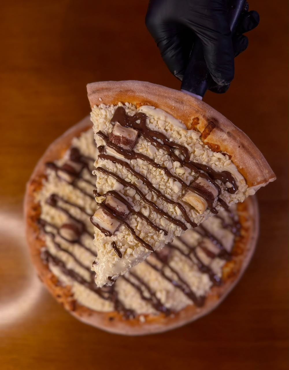 Pizza doce de chocolate branco ralado com cubos de chocolate e fio ao leite