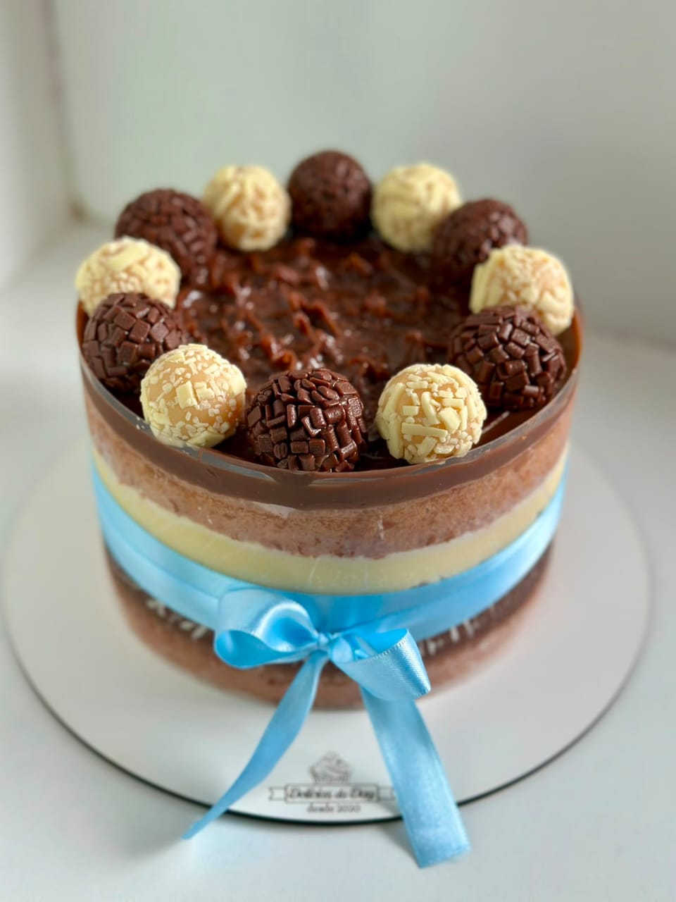 Bolo de camadas coberto com brigadeiros